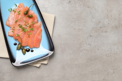 Photo of Delicious salmon carpaccio served on light grey table, top view. Space for text