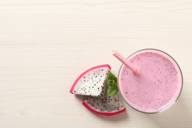 Photo of Delicious pitahaya smoothie with mint and fresh fruit on white wooden table, flat lay. Space for text