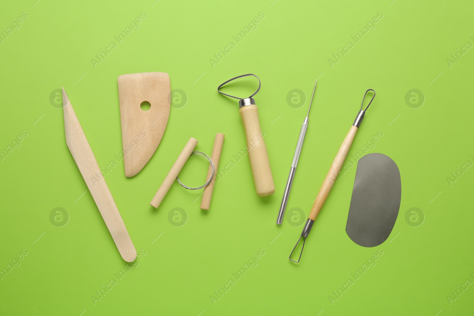 Photo of Set of clay modeling tools on green background, flat lay