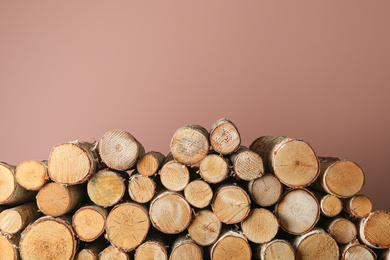 Cut firewood on pink background. Heating in winter