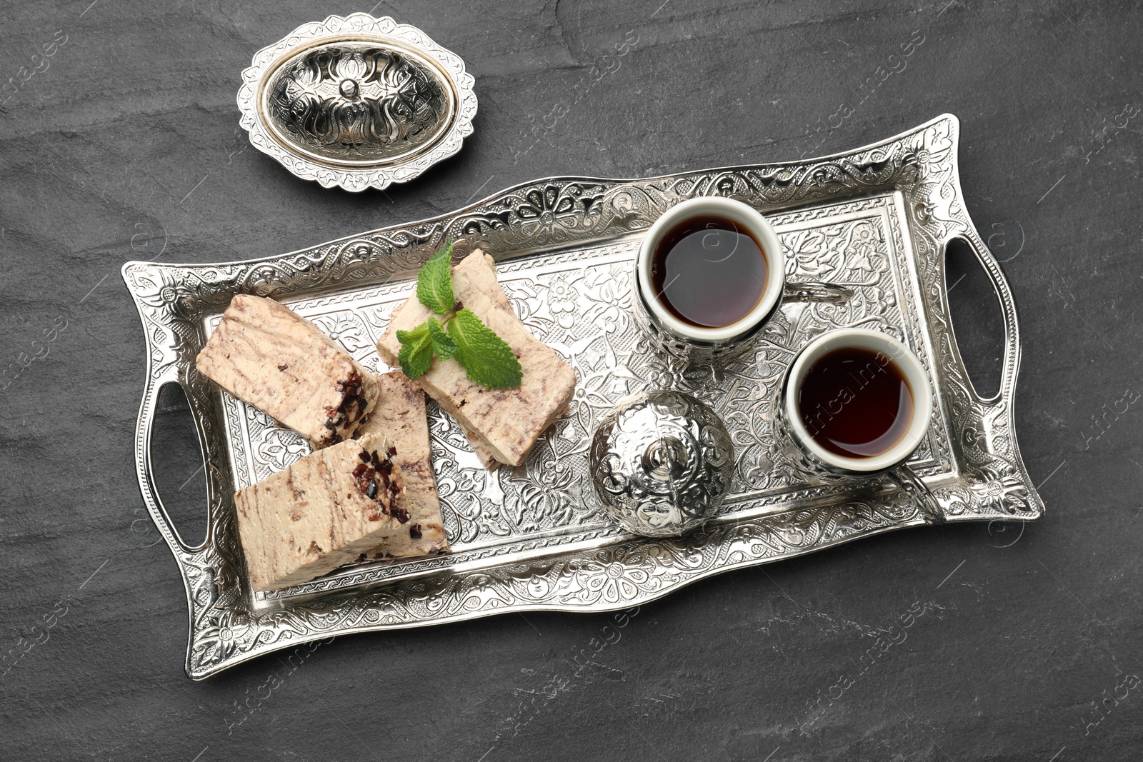 Photo of Tasty chocolate halva served on black table, top view