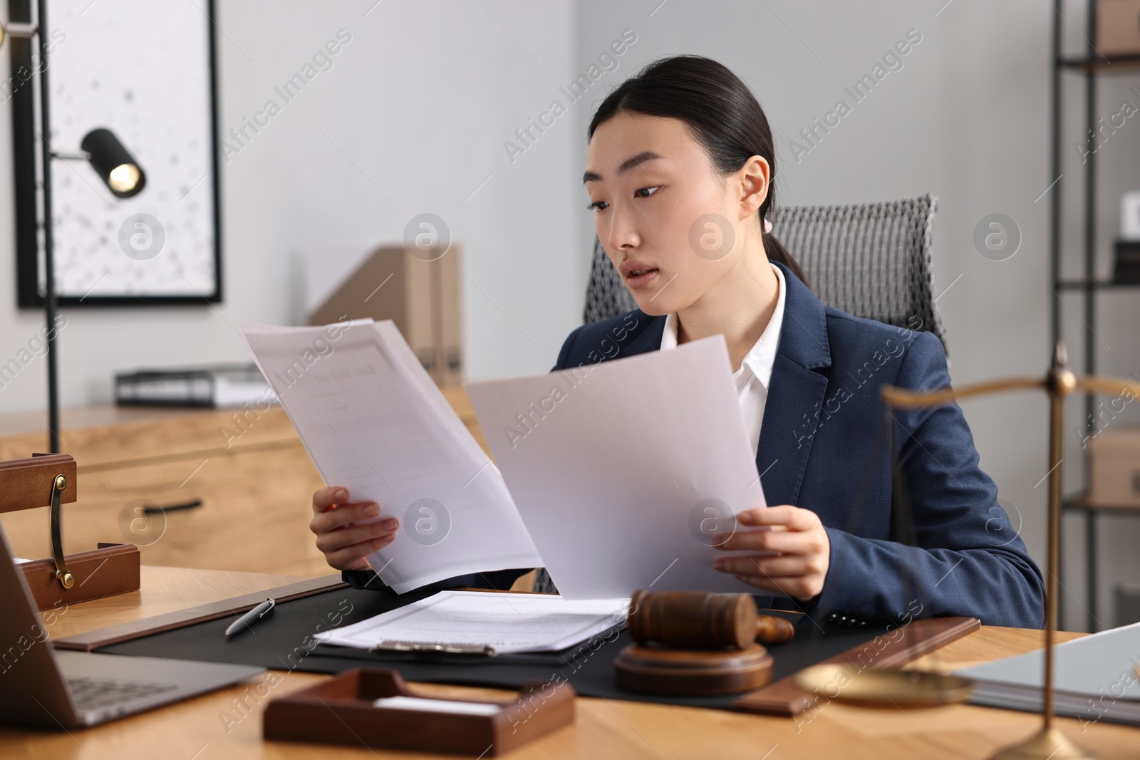 Photo of Notary reading documents at table in office