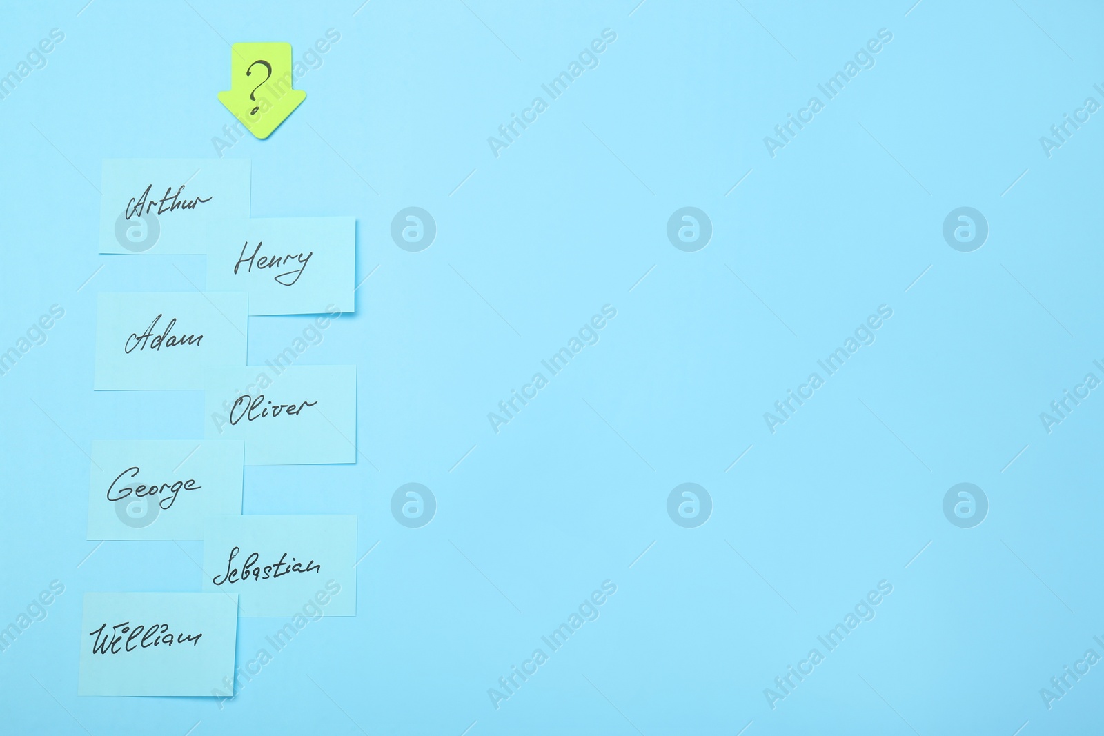 Photo of Choosing baby name. Paper stickers with different names and question mark on light blue background, flat lay. Space for text