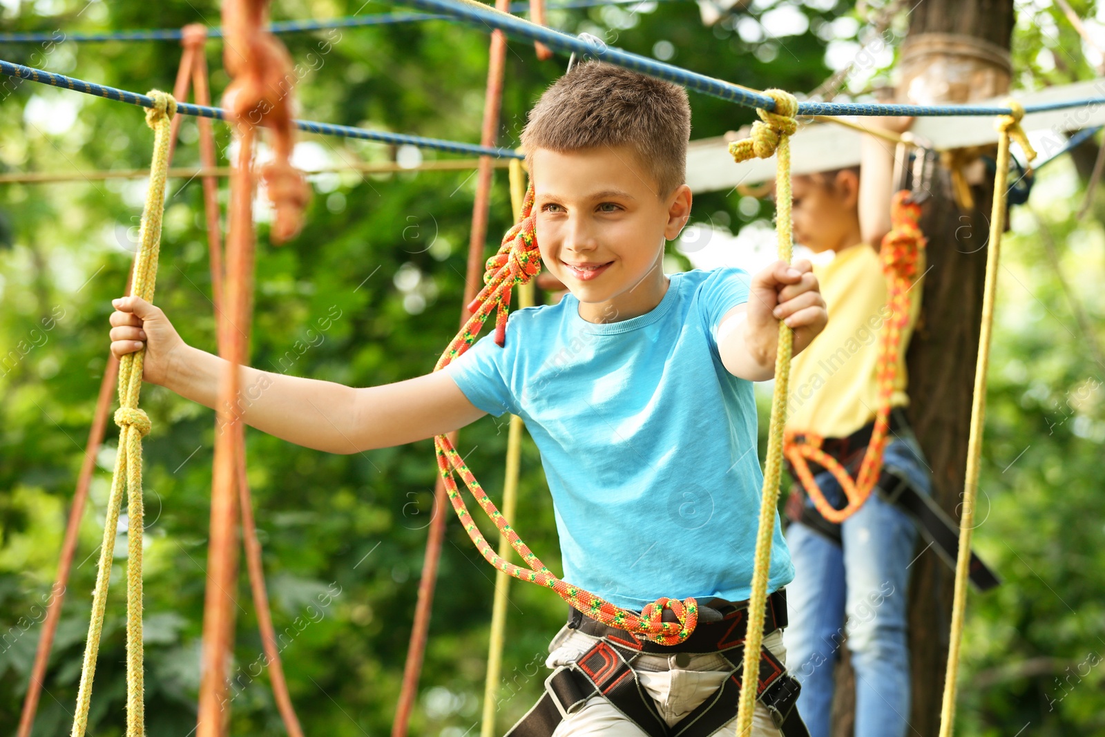 Photo of Little boy climbing in adventure park. Summer camp