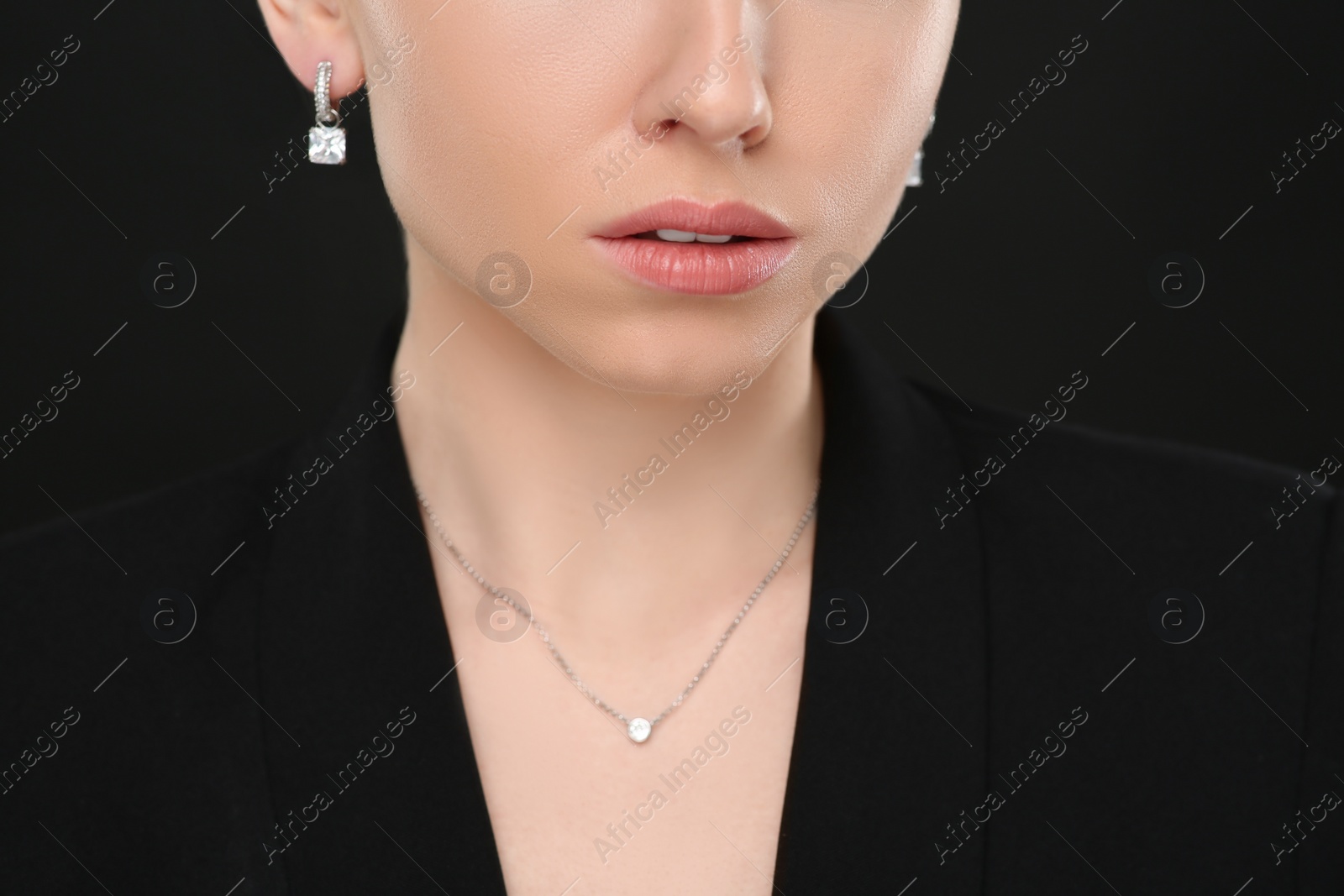 Photo of Woman with elegant jewelry on black background, closeup