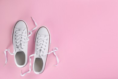 Pair of trendy sneakers on pink background, flat lay. Space for text