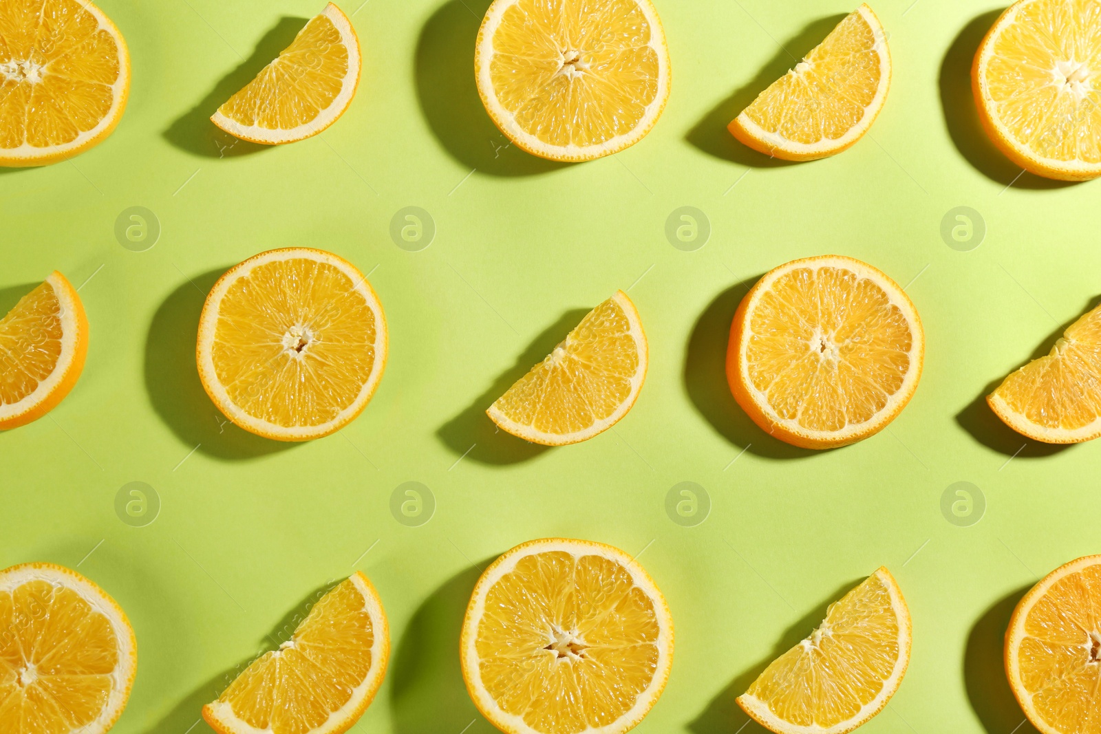 Photo of Slices of delicious oranges on green background, flat lay