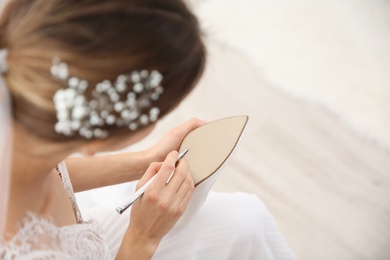 Photo of Young bride writing on her shoe indoors, above view. Wedding superstition