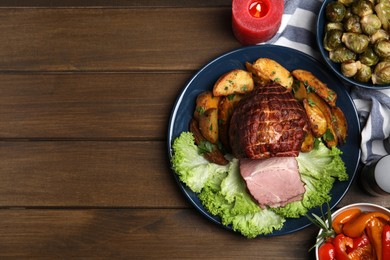 Photo of Flat lay composition with delicious ham and other festive dishes on wooden table, space for text. Christmas dinner