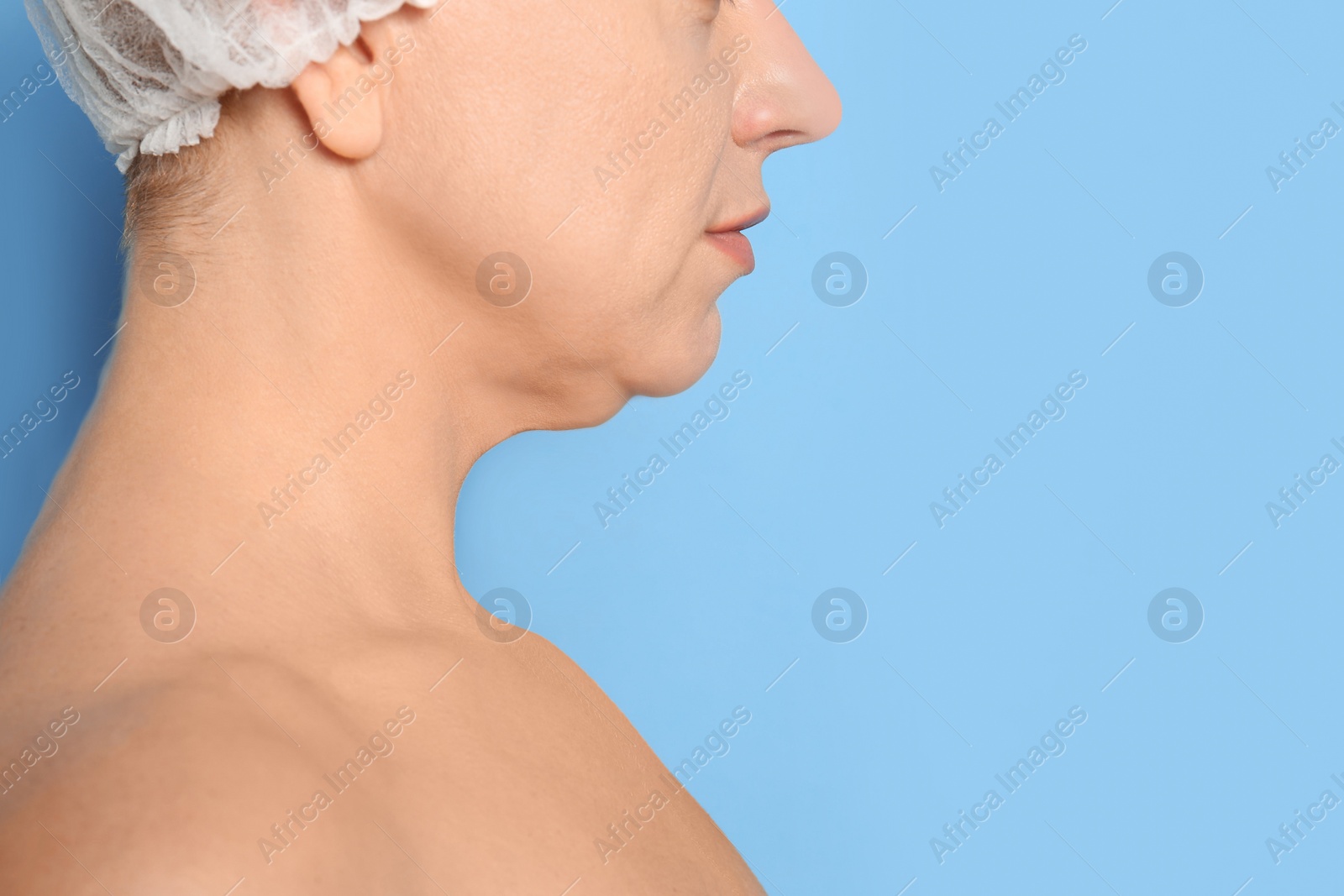 Photo of Mature woman with double chin on blue background, closeup. Space for text