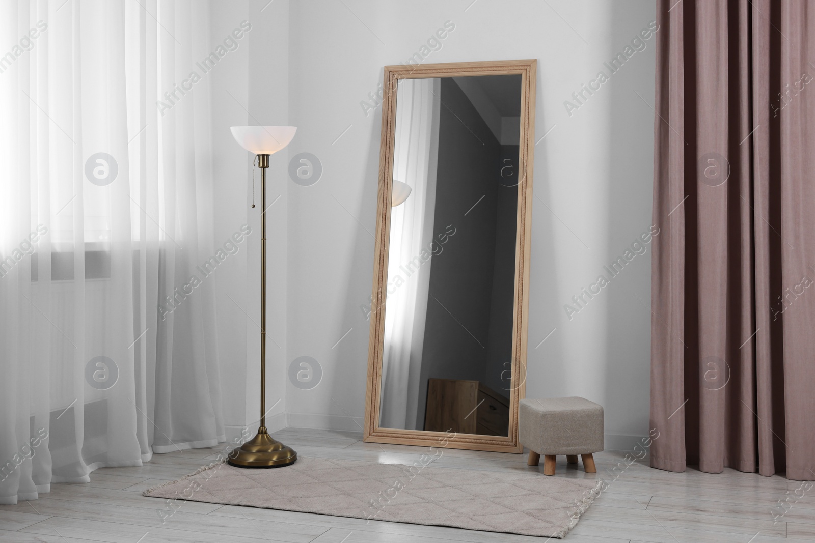 Photo of Stylish makeup room interior with long mirror and lamp