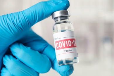 Doctor with coronavirus vaccine in laboratory, closeup