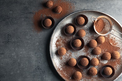 Photo of Flat lay composition with tasty chocolate truffles on grey background, space for text