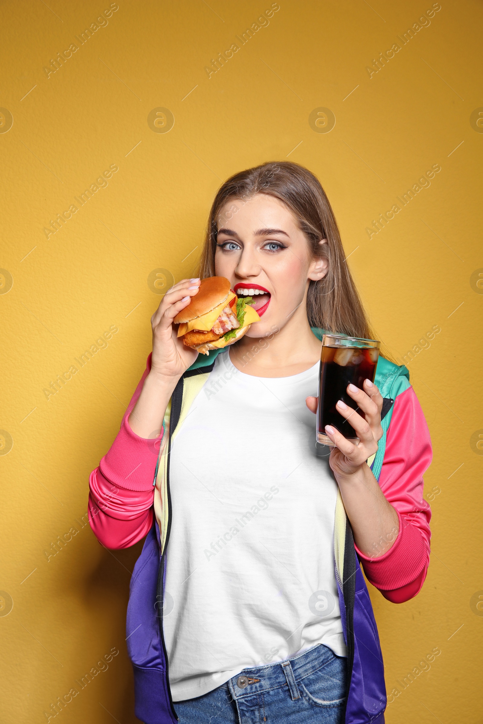 Photo of Pretty woman with tasty burger and cola on color background