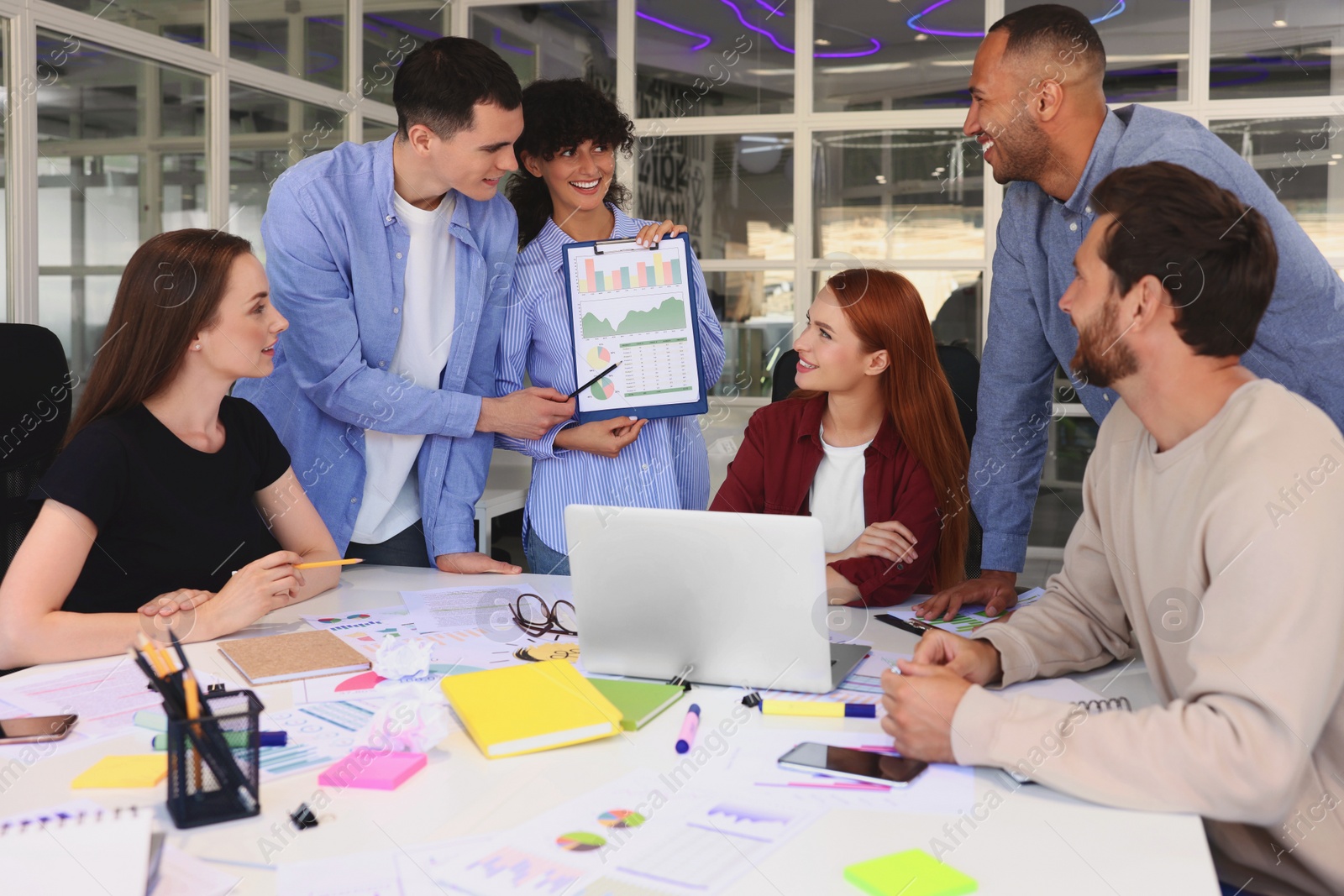 Photo of Team of employees working together at table in office. Startup project