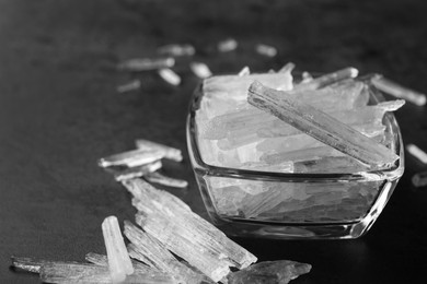 Menthol crystals in bowl on grey background, closeup