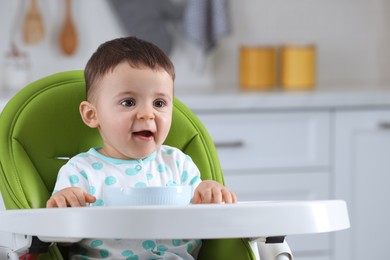 Photo of Cute little baby eating healthy food in high chair at home, space for text