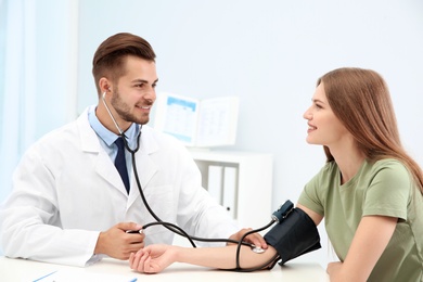 Photo of Doctor checking young woman's pulse in hospital