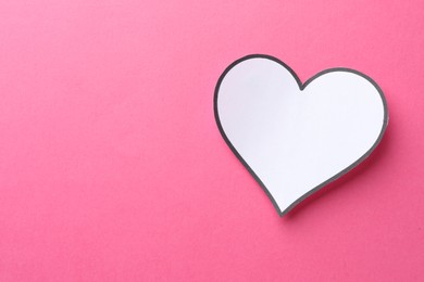 White paper heart on pink background, top view. Space for text