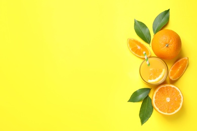 Photo of Glass of orange juice and fresh fruits on yellow background, flat lay. Space for text