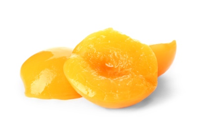 Halves of canned peaches on white background