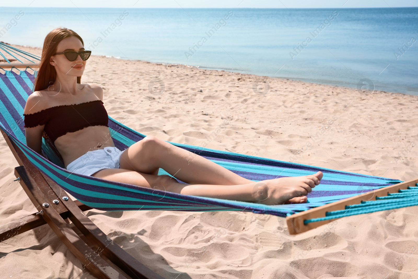 Photo of Young woman relaxing in hammock on beach