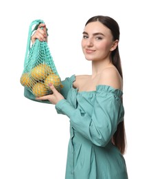 Photo of Woman with string bag of fresh lemons on white background