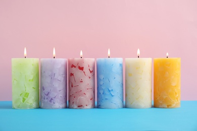 Photo of Alight scented wax candles on color background