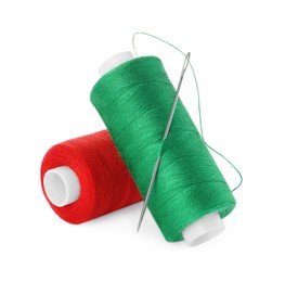 Different colorful sewing threads and needle on white background
