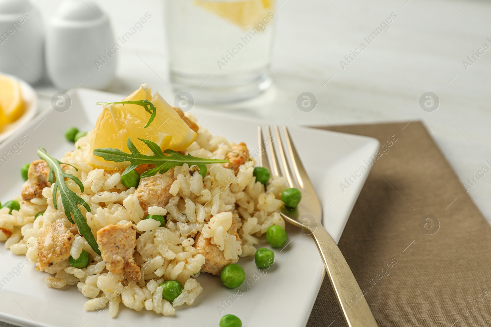 Photo of Delicious chicken risotto with lemon on table, closeup