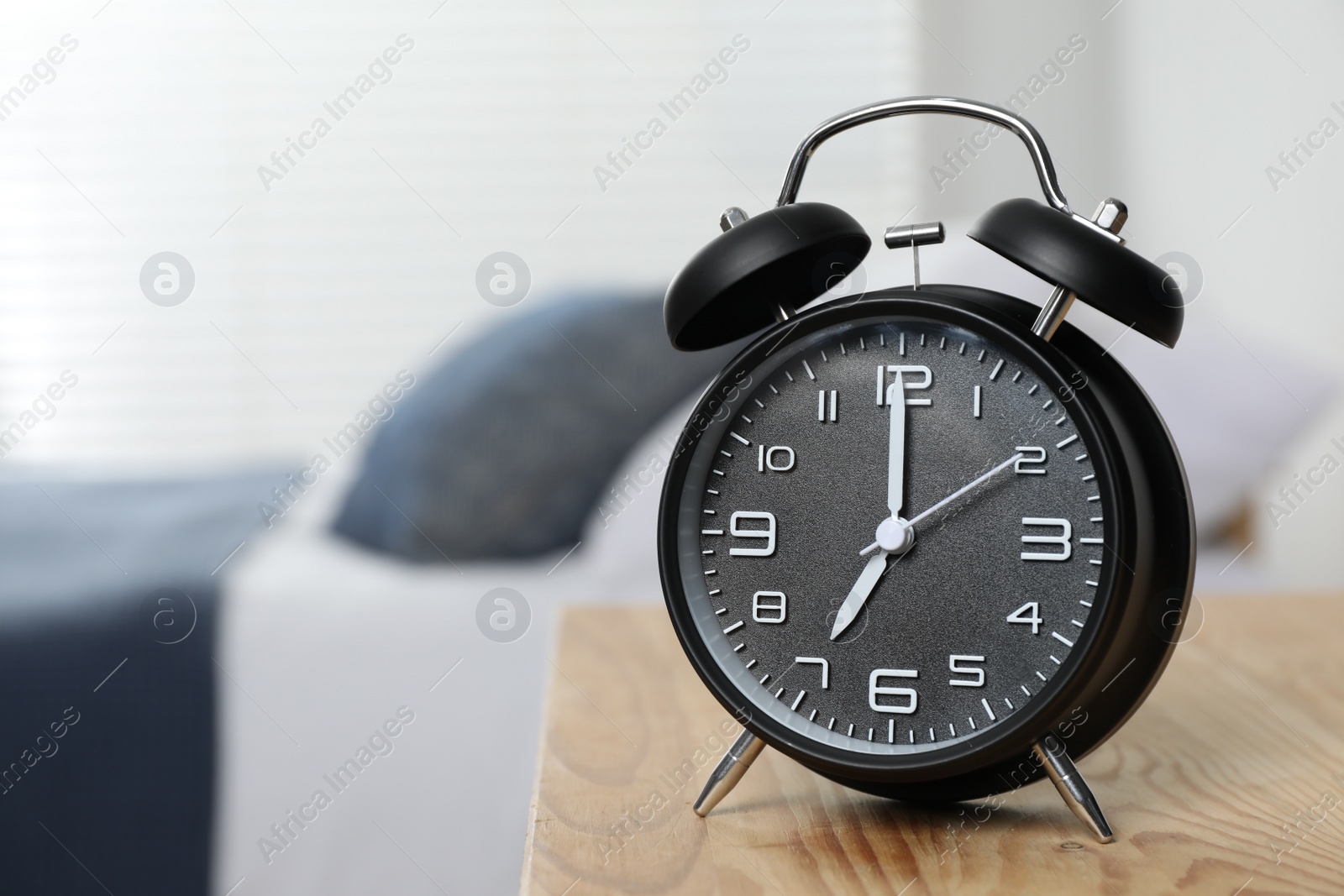 Photo of Black alarm clock on wooden nightstand in bedroom, space for text