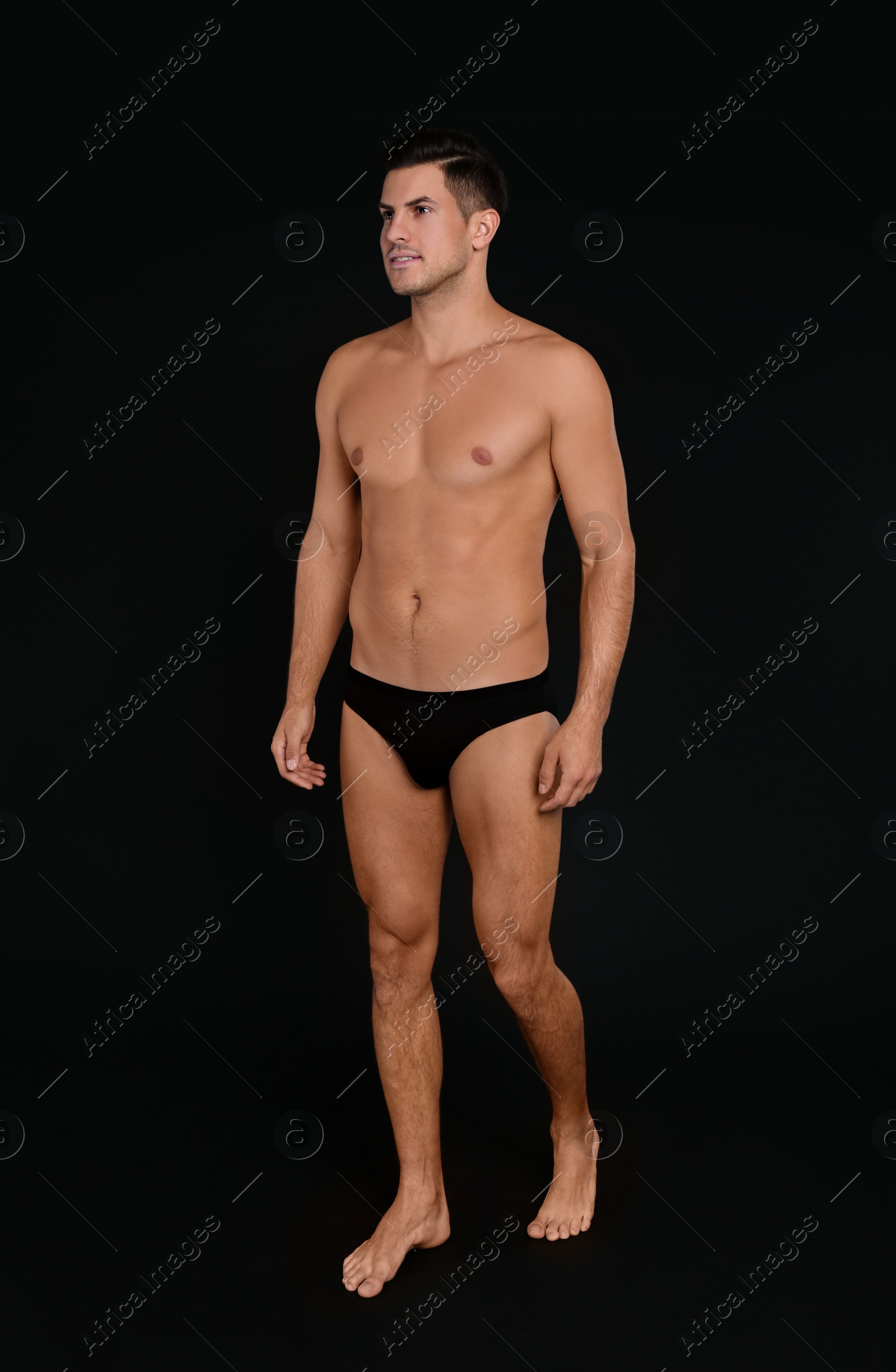 Photo of Handsome man in underwear on black background