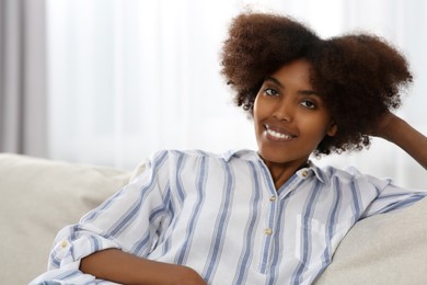 Photo of Smiling African American woman on sofa at home