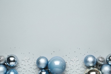 Photo of Flat lay composition with Christmas balls and decor on light background, space for text