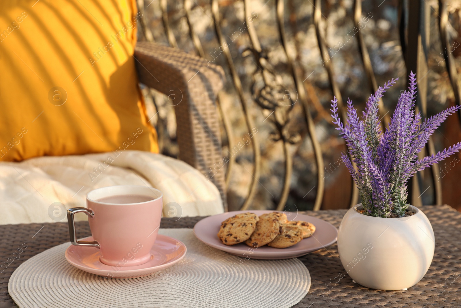 Photo of Cup with tasty cocoa and cookies on rattan table at balcony