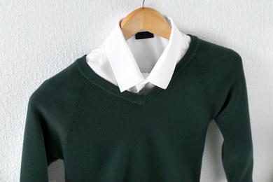 Photo of Shirt and jumper on hanger indoors. School uniform