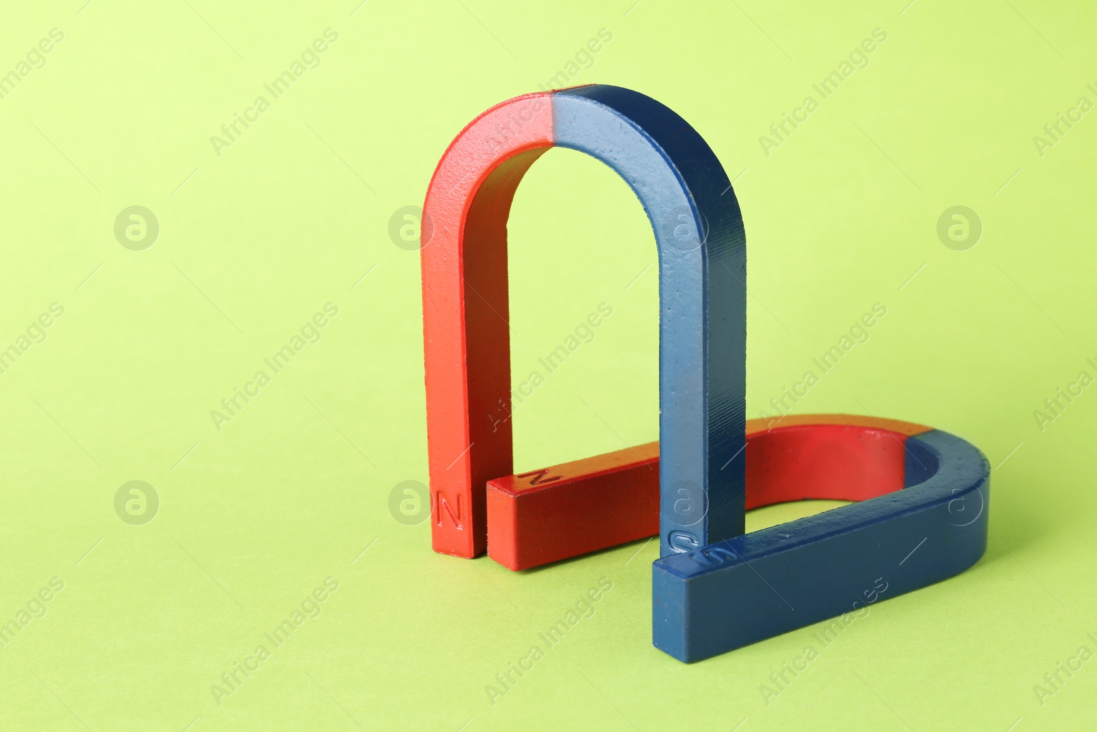 Photo of Red and blue horseshoe magnets on color background. Space for text