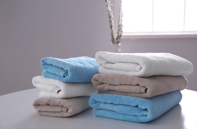 Stacks of clean towels on table indoors