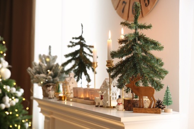 Photo of Small fir trees and Christmas decor on shelf indoors, space for text. Interior design