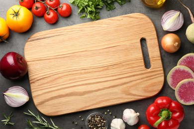 Photo of Flat lay composition with wooden cutting board and products on dark textured table