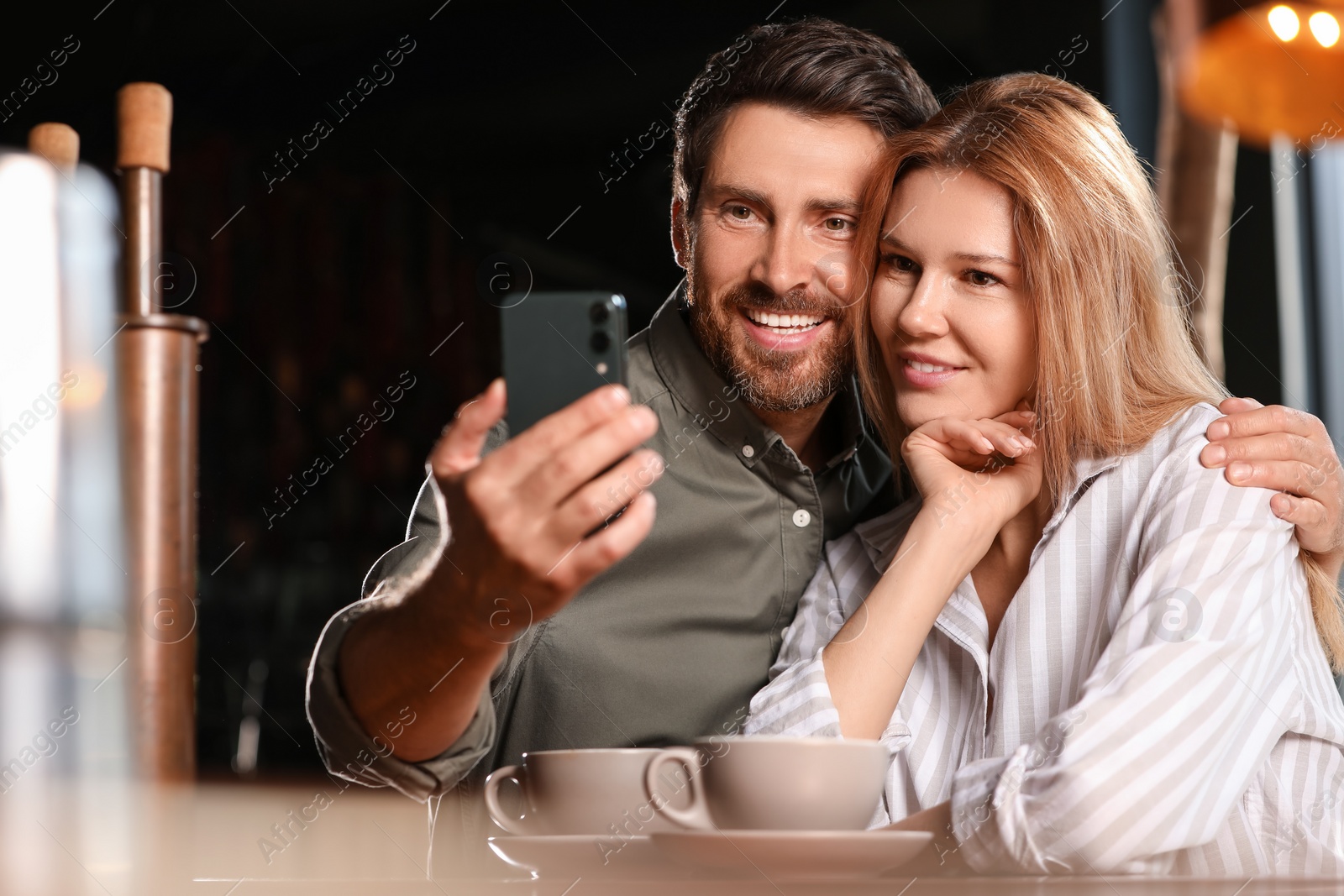 Photo of Romantic date. Happy couple taking selfie in cafe