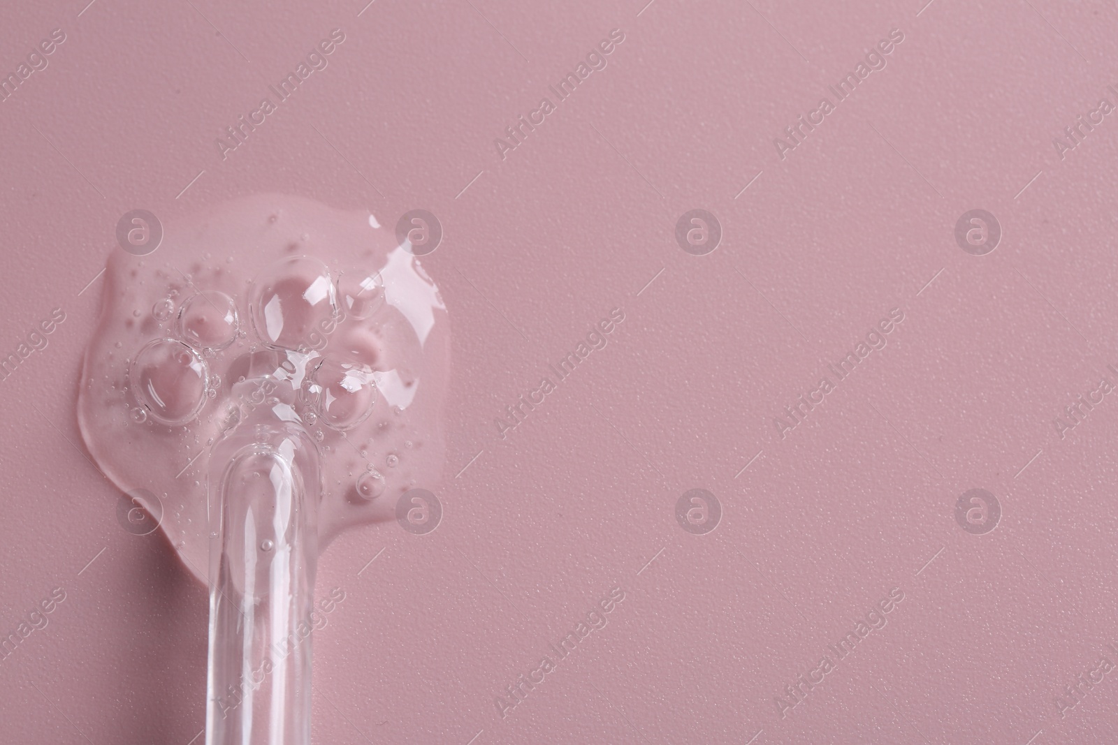 Photo of Pipette with cosmetic serum on pink background, top view. Space for text