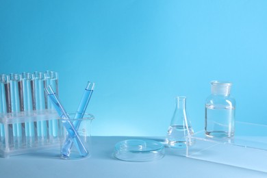 Photo of Laboratory analysis. Different glassware on table against light blue background