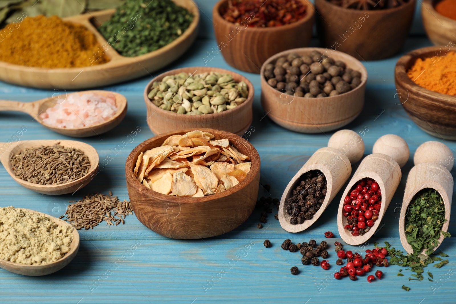 Photo of Many different spices on light blue wooden table