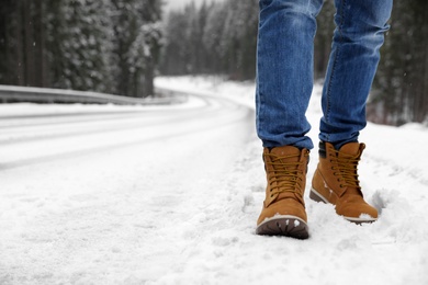 Man walking outdoors on snowy winter day. Space for text