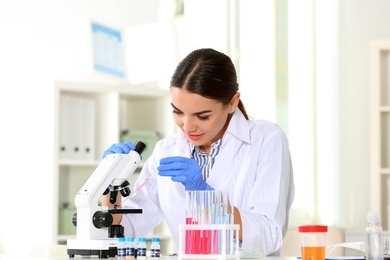 Photo of Female scientist working at table in laboratory. Research and analysis