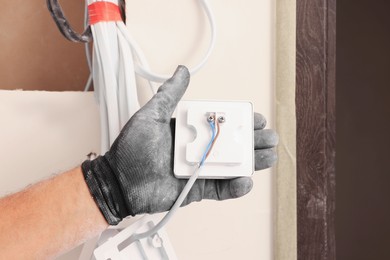 Electrician installing remote meter indoors, closeup. Installation of electrical wiring