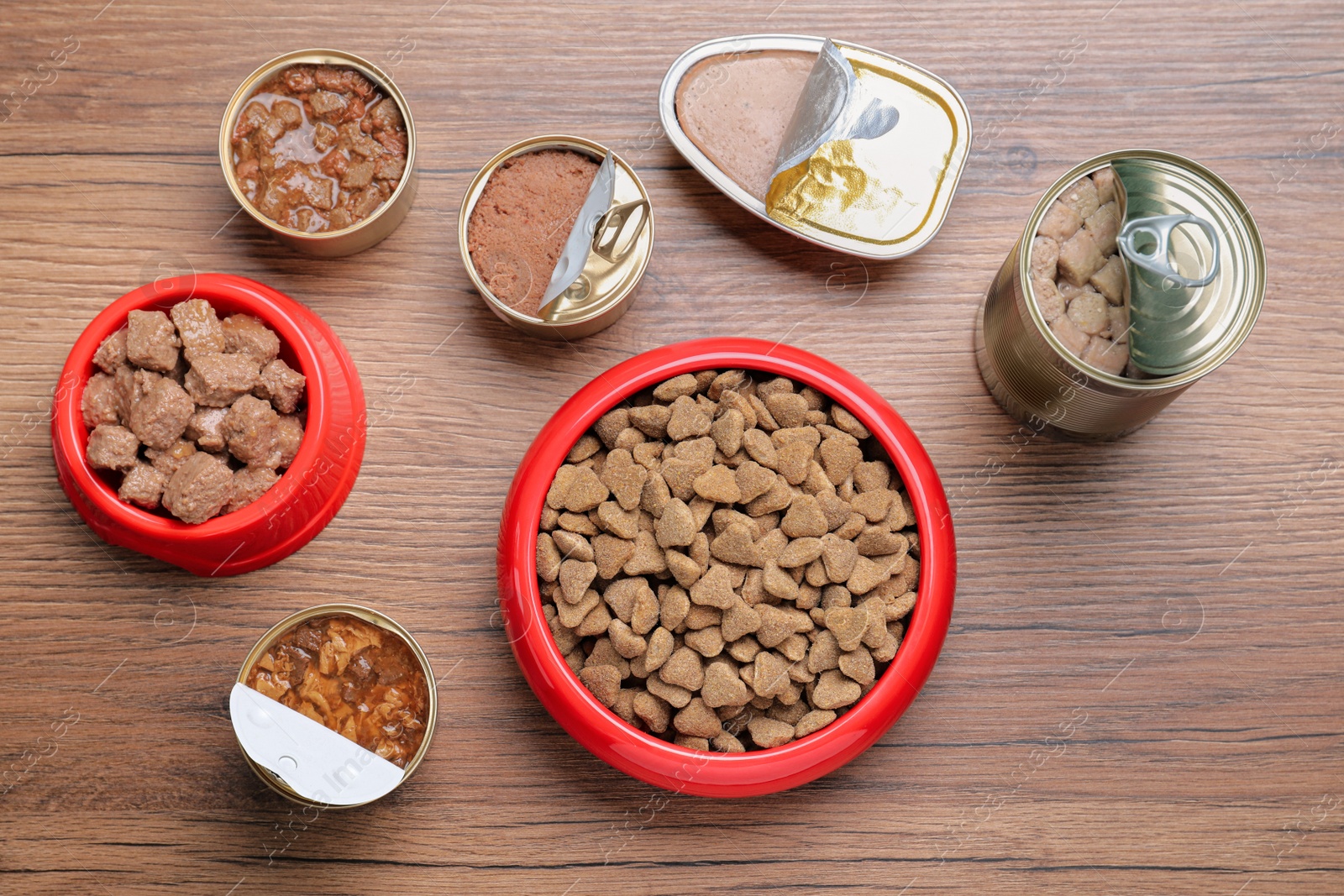Photo of Wet and dry pet food on wooden table, flat lay