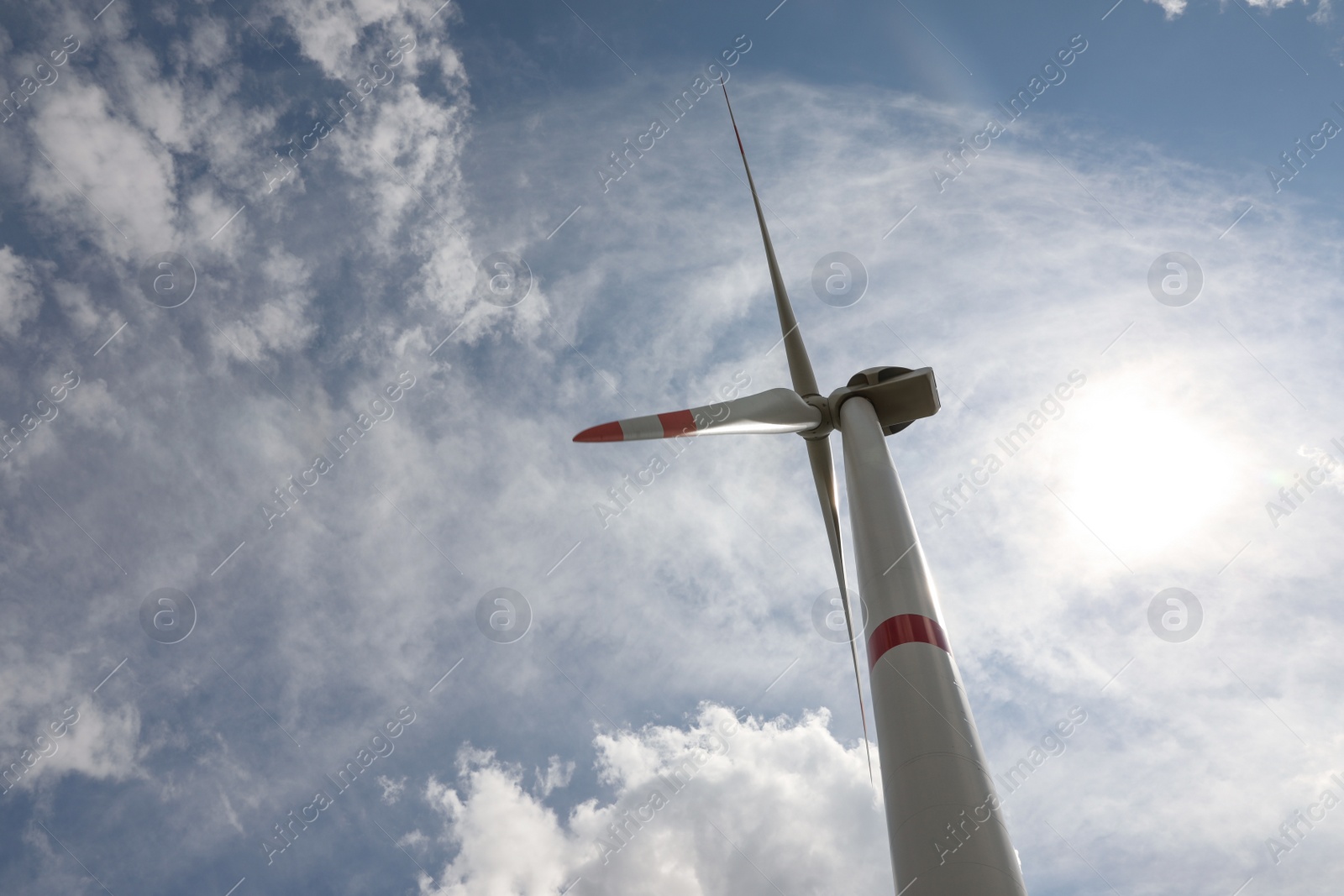 Photo of Modern wind turbine against cloudy sky, low angle view. Alternative energy source