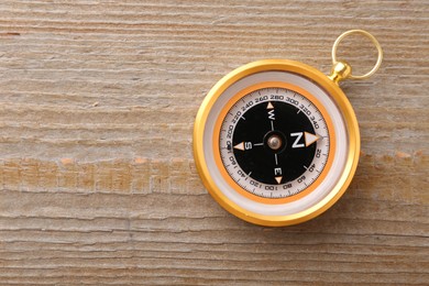 One compass on wooden table, top view. Space for text